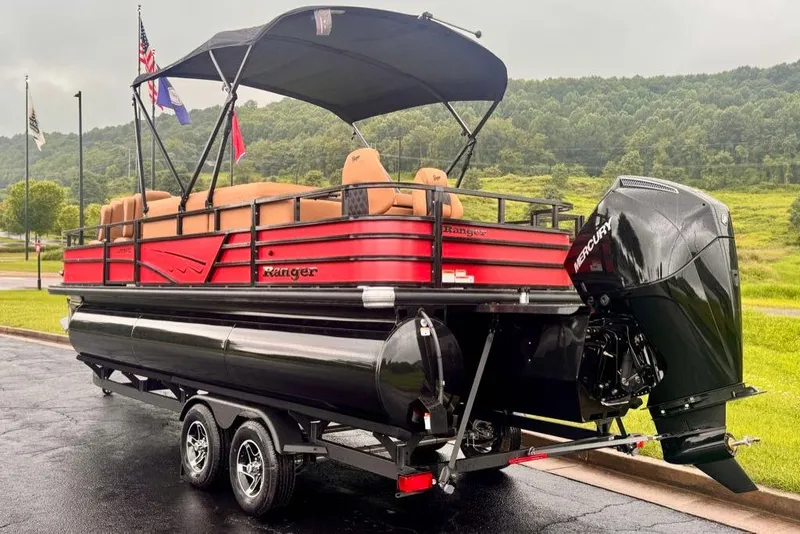 Slide: The Image of 2026 Ranger 223FC pontoon boat with Mercury engine on a trailer, parked outdoors. - 5
