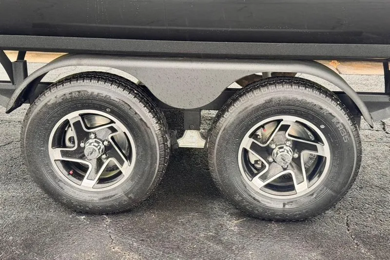 Slide: The Image of Dual wheels of a 2026 Ranger 223FC trailer on wet pavement. - 18