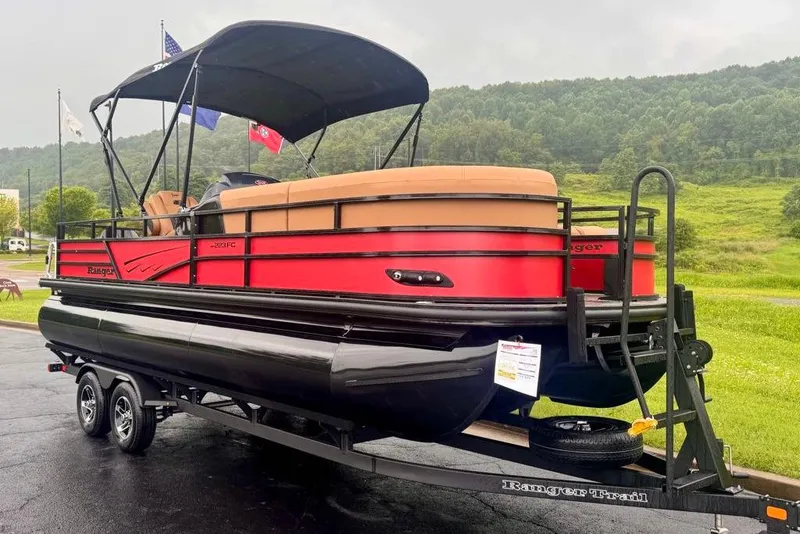 Slide: The Image of 2026 Ranger 223FC pontoon boat on trailer, red and black design, parked outdoors. - 1