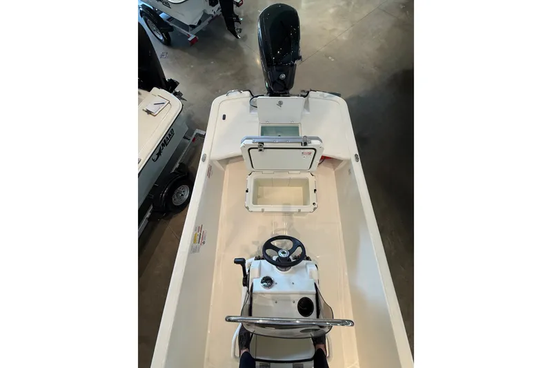 Slide: The Image of 2026 Mako Pro Skiff 17 CC boat interior with open storage compartments and steering console. - 9