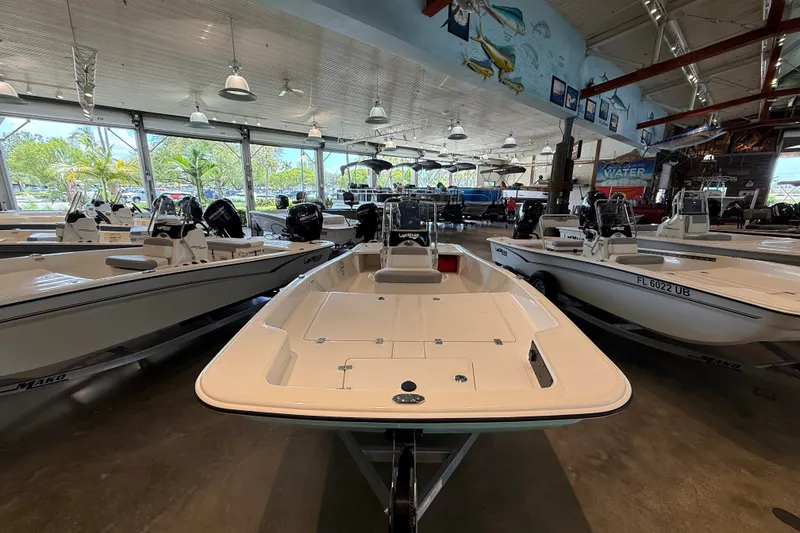 The Image of 2026 Mako Pro Skiff 17 CC displayed in a showroom with other boats. - 0