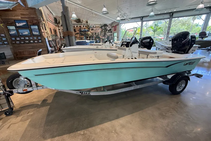 Slide: The Image of 2026 Mako Pro Skiff 17 CC boat displayed in a showroom, featuring a sleek design. - 1