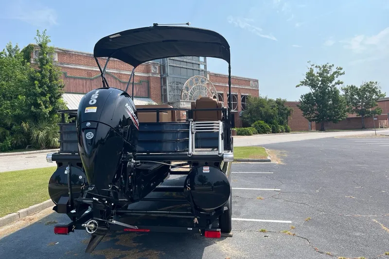 Slide: The Image of 2026 Ranger 220FC boat with Mercury engine parked near a historic building. - 5