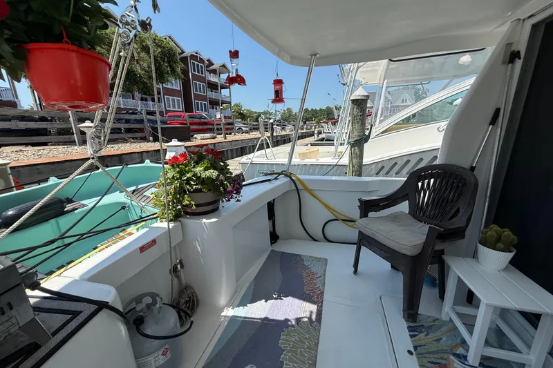 Slide: The Image of Cozy deck of 2000 Mainship 390 Trawler with plants and seating, docked at marina. - 8