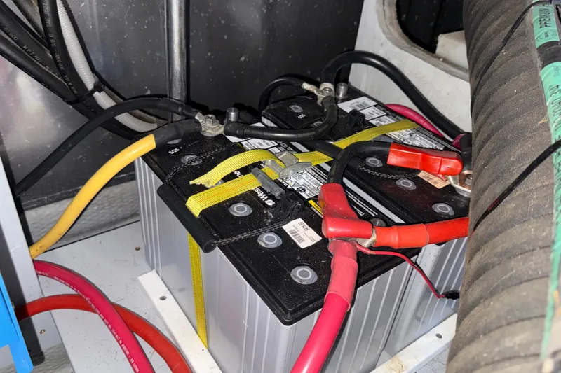 Slide: The Image of Battery compartment of a 2000 Mainship 390 Trawler with connected cables. - 82
