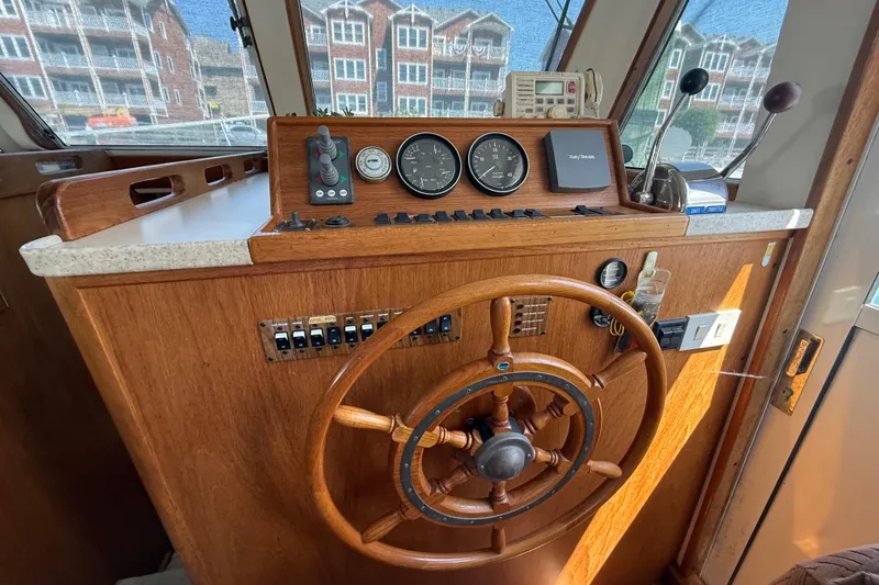 Slide: The Image of Helm of 2000 Mainship 390 Trawler with wooden wheel and navigation instruments. - 57
