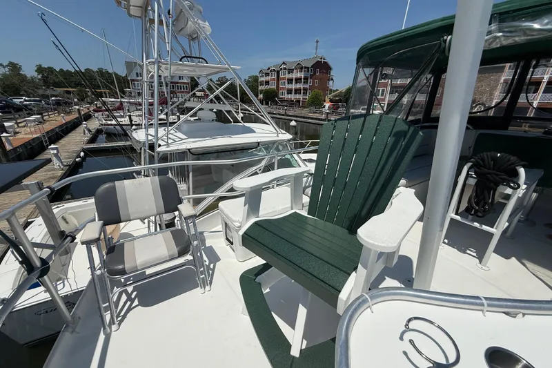 Slide: The Image of 2000 Mainship 390 Trawler deck with chairs, docked at marina under clear sky. - 32