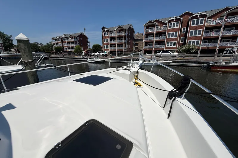 Slide: The Image of 2000 Mainship 390 Trawler docked near waterfront apartments on a sunny day. - 50
