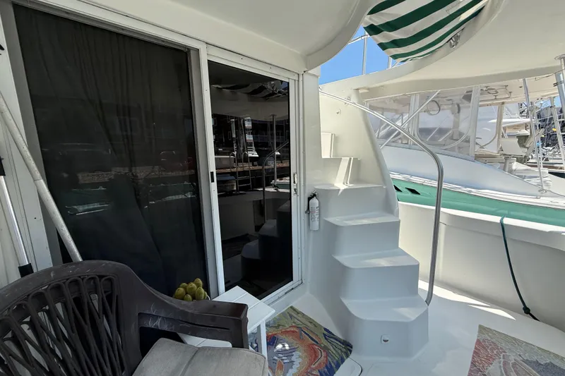 Slide: The Image of 2000 Mainship 390 Trawler interior with stairs, sliding door, and outdoor seating area. - 9