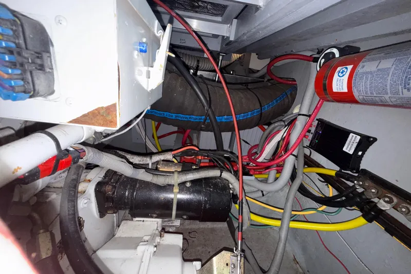 Slide: The Image of Engine compartment of a 2000 Mainship 390 Trawler with wiring and fire extinguisher. - 89