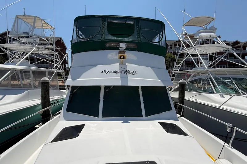 Slide: The Image of 2000 Mainship 390 Trawler docked at marina, front view with green canopy. - 52