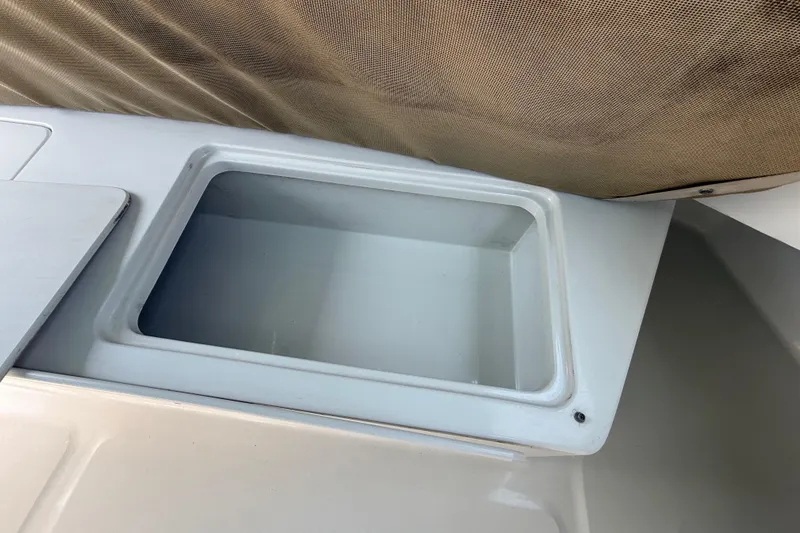 Slide: The Image of Storage compartment on a 2000 Mainship 390 Trawler boat, featuring a beige cushion. - 25