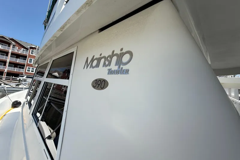 Slide: The Image of 2000 Mainship 390 Trawler boat docked near waterfront buildings. - 13