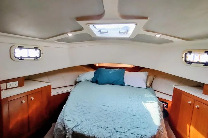 Slide: The Image of Cozy cabin interior of 2000 Mainship 390 Trawler with bed and wooden cabinets. - 70