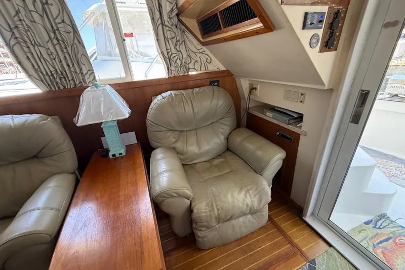 Slide: The Image of Interior of 2000 Mainship 390 Trawler with leather chair, wooden table, and lamp. - 55