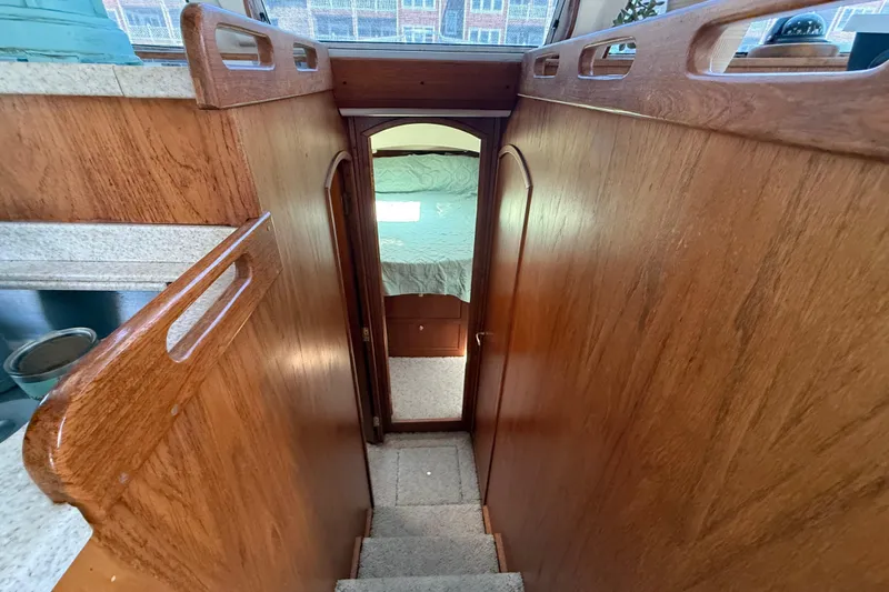Slide: The Image of Interior view of 2000 Mainship 390 Trawler, featuring wooden stairs and cozy cabin entrance. - 69
