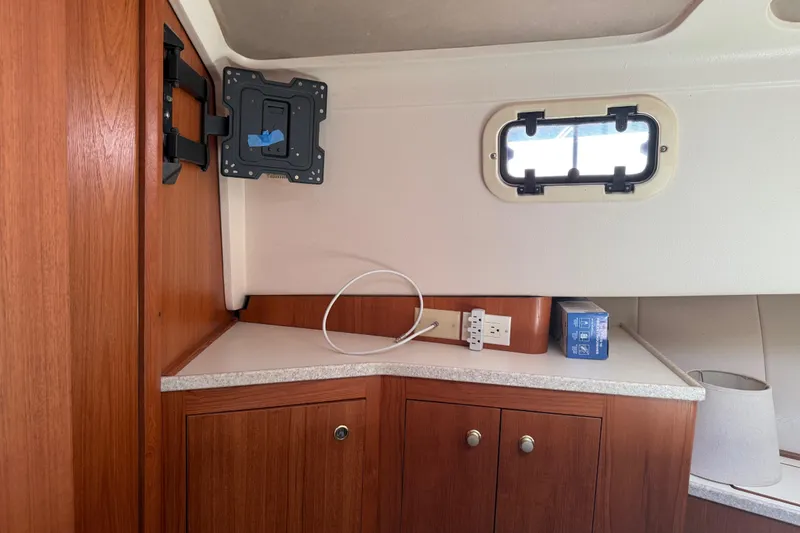 Slide: The Image of Interior of a 2000 Mainship 390 Trawler with wood cabinetry and a small window. - 73