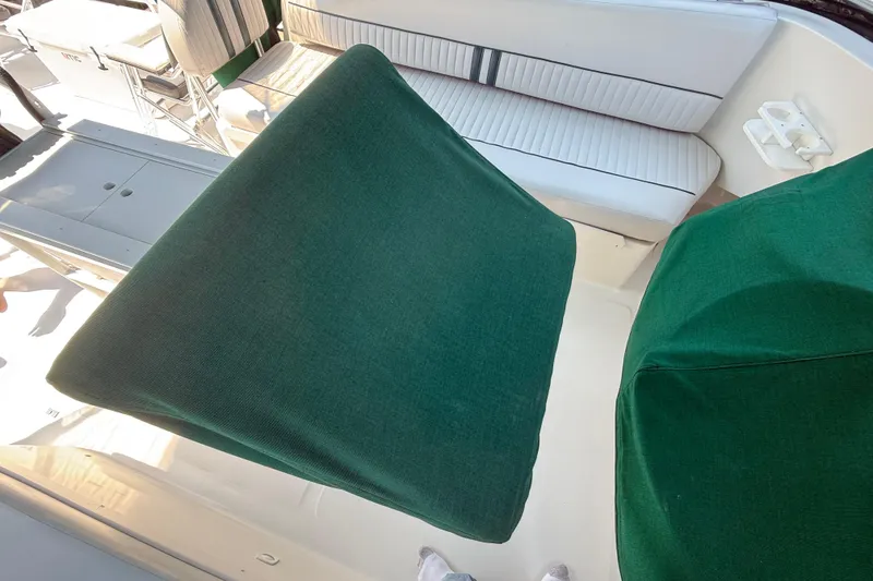 Slide: The Image of 2000 Mainship 390 Trawler interior with green seat covers and white-striped seating. - 18
