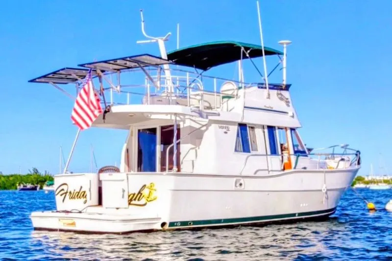 The Image of 2000 Mainship 390 Trawler on water, American flag, sunny day. - 0