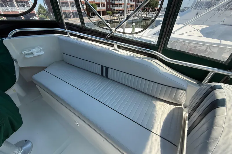 Slide: The Image of Interior seating of 2000 Mainship 390 Trawler with cushioned bench and windows. - 23