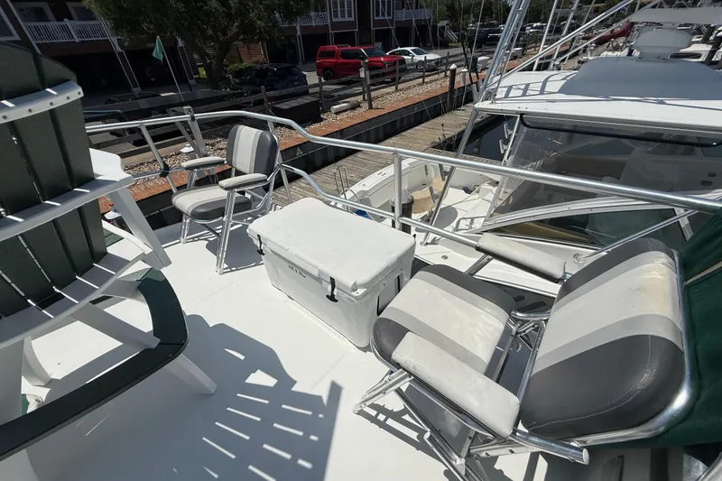 Slide: The Image of 2000 Mainship 390 Trawler deck with chairs and cooler, docked at marina. - 28