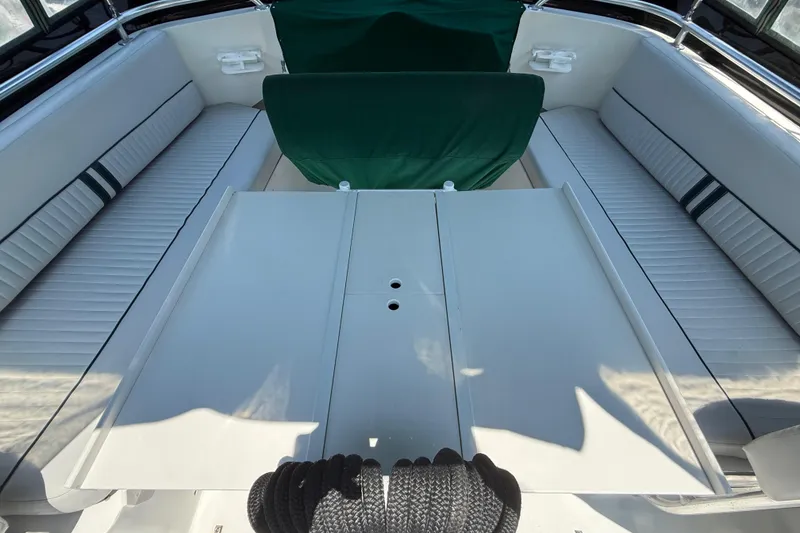 Slide: The Image of 2000 Mainship 390 Trawler interior with white seating and green covers. - 21