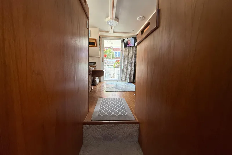 Slide: The Image of Interior view of 2000 Mainship 390 Trawler, featuring cozy wooden paneling and carpeted steps. - 72