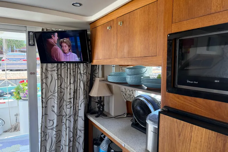 Slide: The Image of Interior of 2000 Mainship 390 Trawler with TV, microwave, and wooden cabinetry. - 66