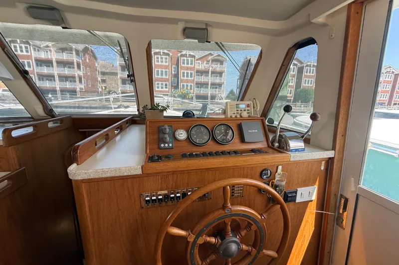 Slide: The Image of Interior helm of 2000 Mainship 390 Trawler with wooden steering wheel and navigation instruments. - 59