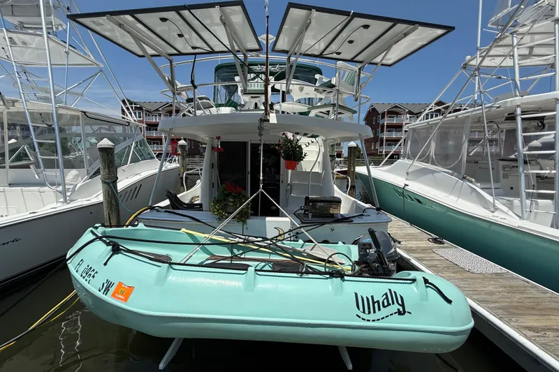 Slide: The Image of 2000 Mainship 390 Trawler docked with a small Whaly boat attached, sunny marina setting. - 4