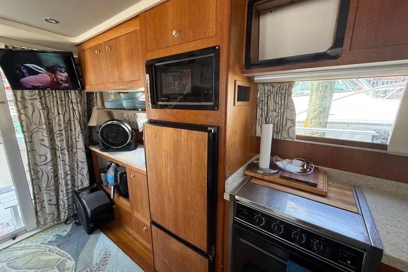 Slide: The Image of Interior of 2000 Mainship 390 Trawler with kitchen appliances and wooden cabinetry. - 68