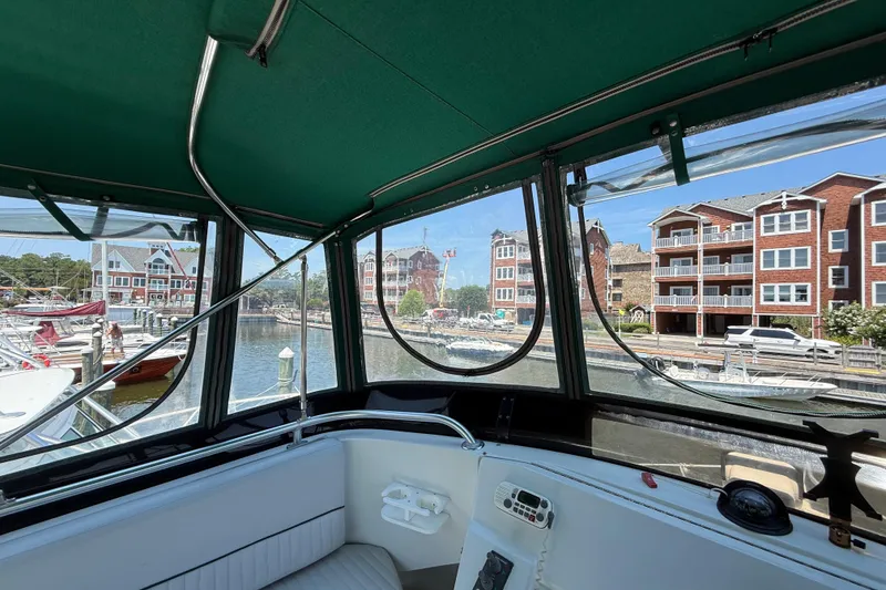 Slide: The Image of Interior view from a 2000 Mainship 390 Trawler, overlooking a marina with waterfront buildings. - 38