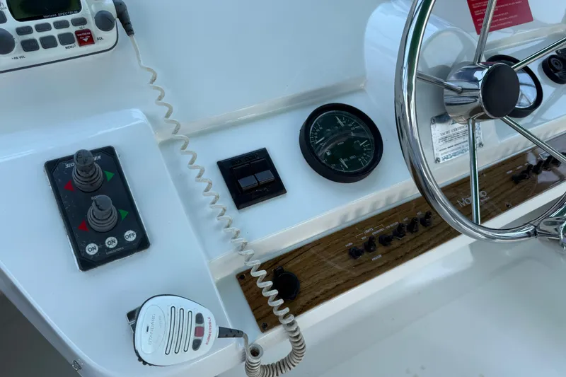 Slide: The Image of Helm of 2000 Mainship 390 Trawler with steering wheel, controls, and gauges. - 49