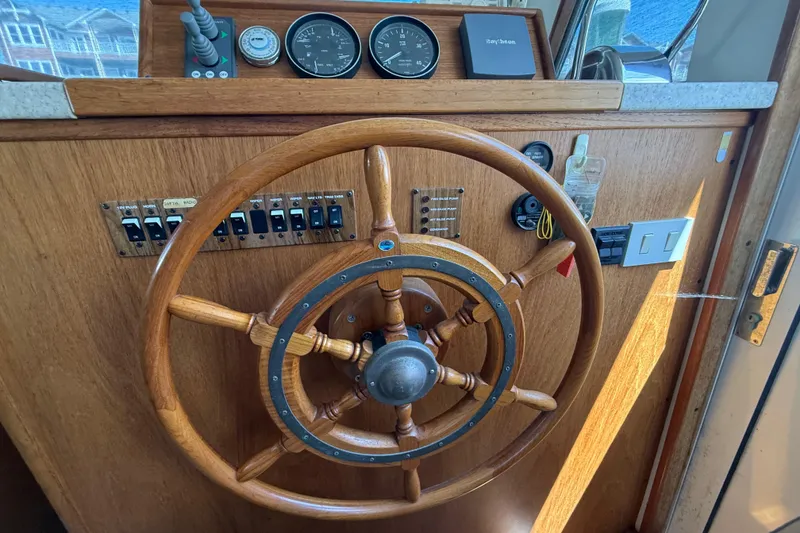 Slide: The Image of Wooden helm of a 2000 Mainship 390 Trawler with gauges and controls. - 58
