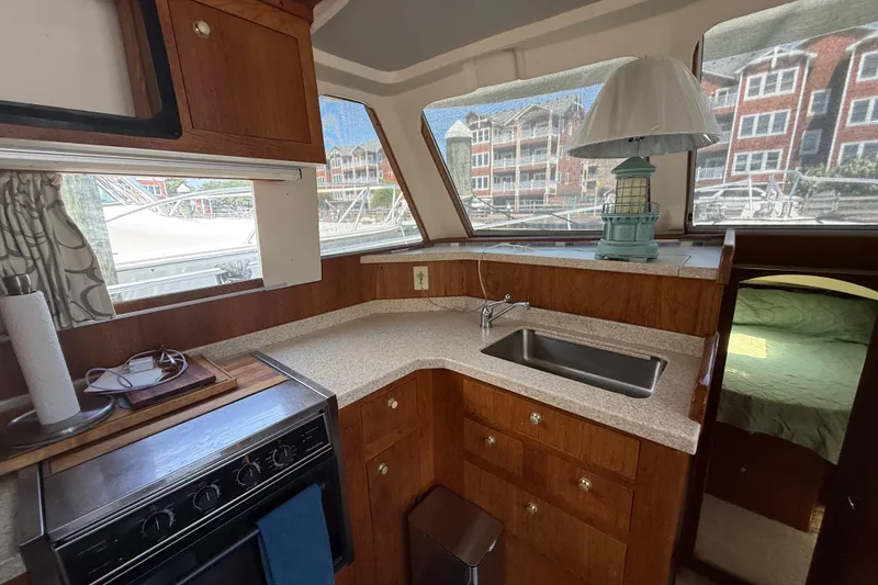 Slide: The Image of Interior of 2000 Mainship 390 Trawler with kitchen and sink, featuring wood cabinetry. - 62
