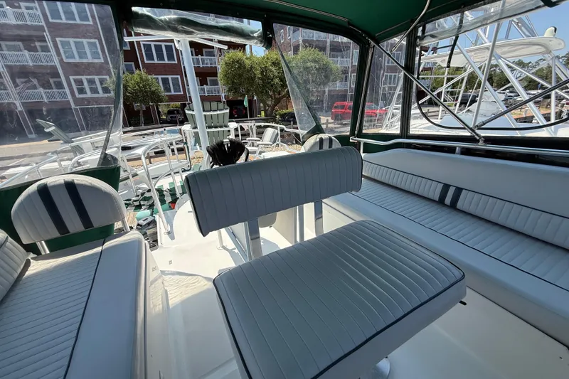 Slide: The Image of Interior view of 2000 Mainship 390 Trawler with white seating and green canopy. - 42