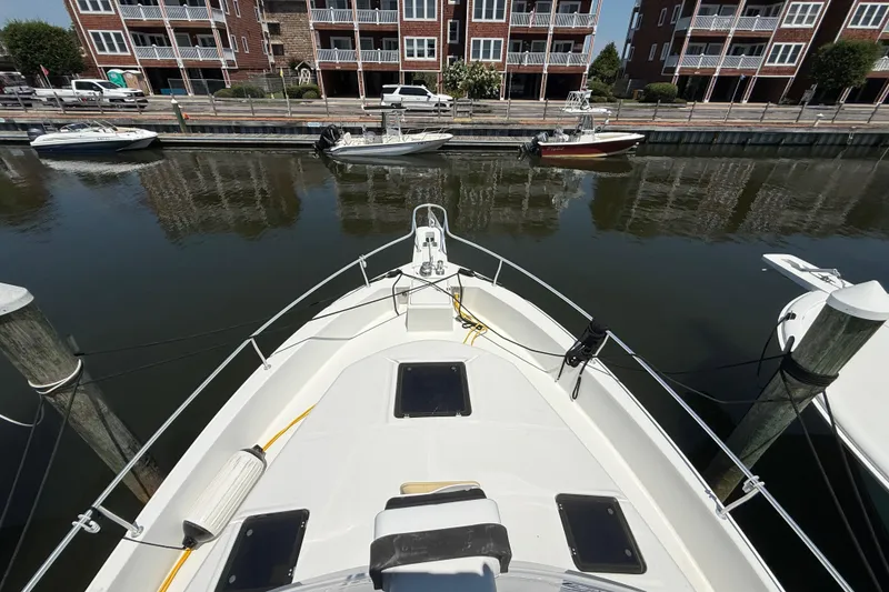 Slide: The Image of Bow view of 2000 Mainship 390 Trawler docked near waterfront buildings. - 16
