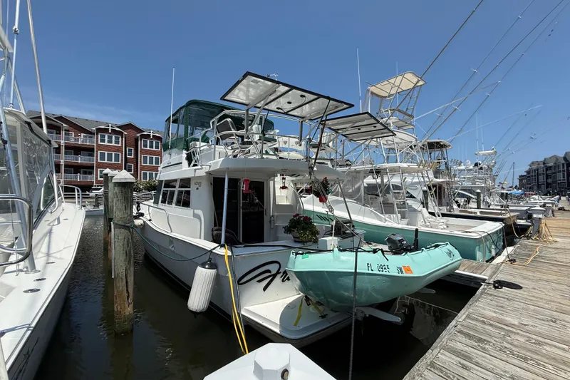 Slide: The Image of 2000 Mainship 390 Trawler docked at marina, surrounded by other boats under clear blue sky. - 3