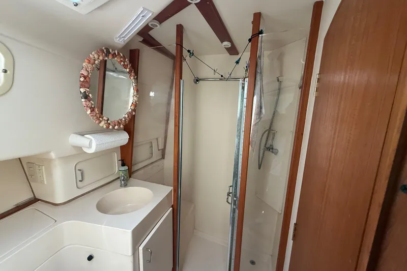 Slide: The Image of Bathroom interior of 2000 Mainship 390 Trawler with shower and seashell mirror. - 75