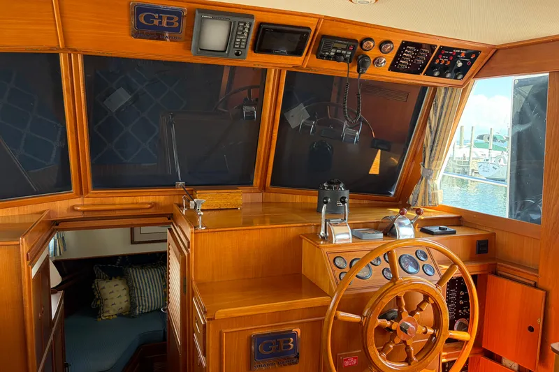 Slide: The Image of Interior helm of 2001 Grand Banks 42 Classic yacht with wooden steering wheel and navigation instruments. - 9