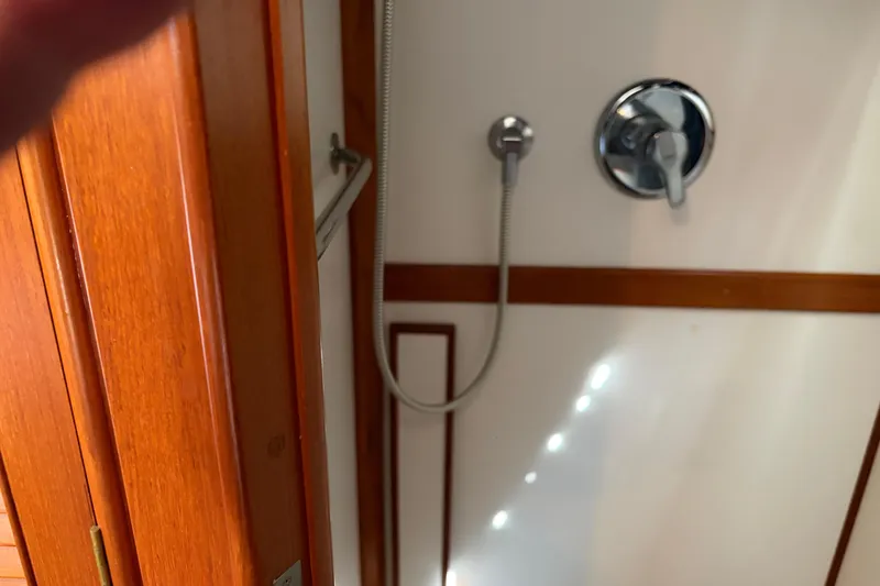 Slide: The Image of Shower area inside a 2001 Grand Banks 42 Classic yacht, featuring wooden trim and chrome fixtures. - 20