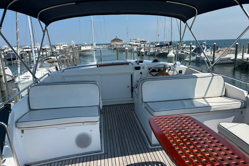 Slide: The Image of Flybridge of 2001 Grand Banks 42 Classic yacht docked at marina, featuring seating and helm. - 5