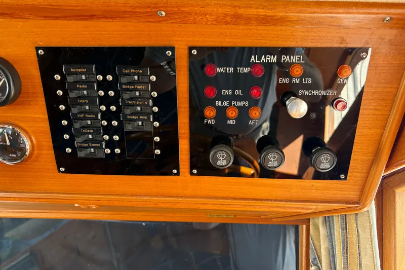 Slide: The Image of Control panel of a 2001 Grand Banks 42 Classic yacht with various switches and indicators. - 13