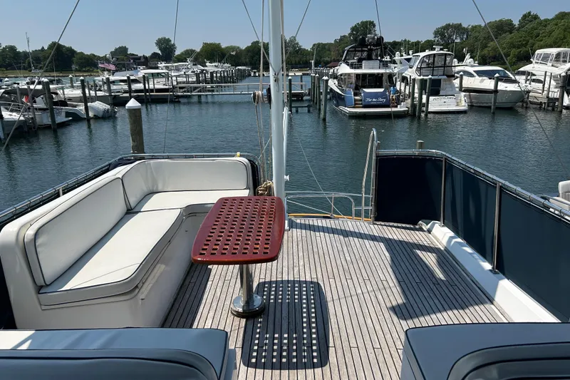 Slide: The Image of 2001 Grand Banks 42 Classic yacht deck with seating, table, and marina view. - 7
