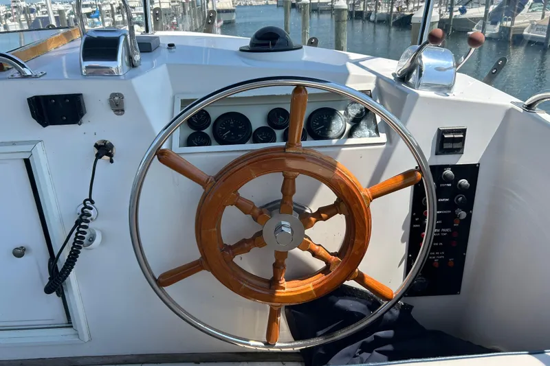 Slide: The Image of Steering wheel of a 2001 Grand Banks 42 Classic yacht at the helm. - 6