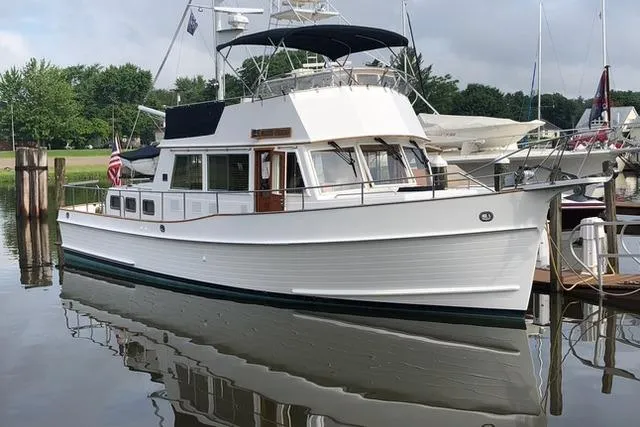 The Image of Grand Banks 42 Classic 2001 yacht docked in a marina, reflecting on calm water. - 0