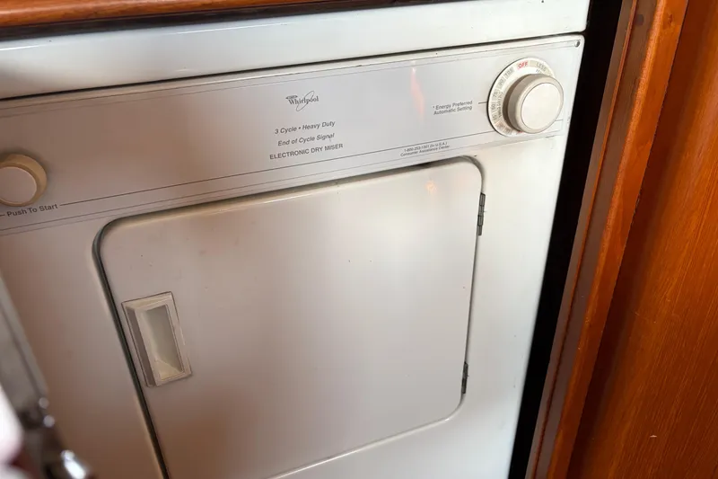Slide: The Image of Whirlpool dryer inside a 2001 Grand Banks 42 Classic yacht, featuring a 3-cycle heavy-duty setting. - 23
