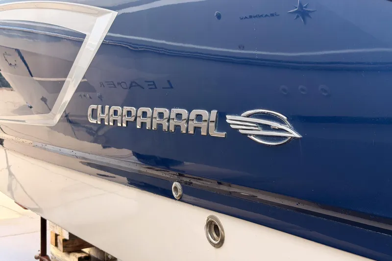 Slide: The Image of 2012 Chaparral 327 SSX boat with blue and white exterior, featuring logo detail. - 26