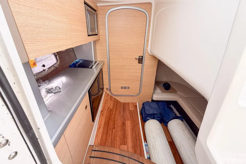 Slide: The Image of Interior of 2012 Chaparral 327 SSX boat with wood finish and compact kitchenette. - 23