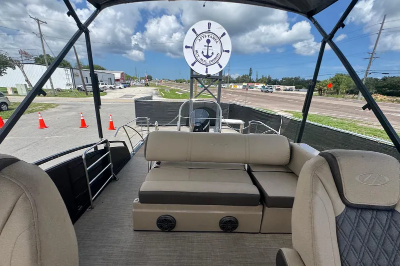 Slide: The Image of 2021 Harris Solstice 230 pontoon boat interior with seating, under a blue sky. - 18
